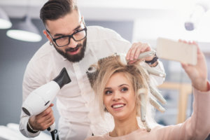 A hairdresser blowdrying client's hair
