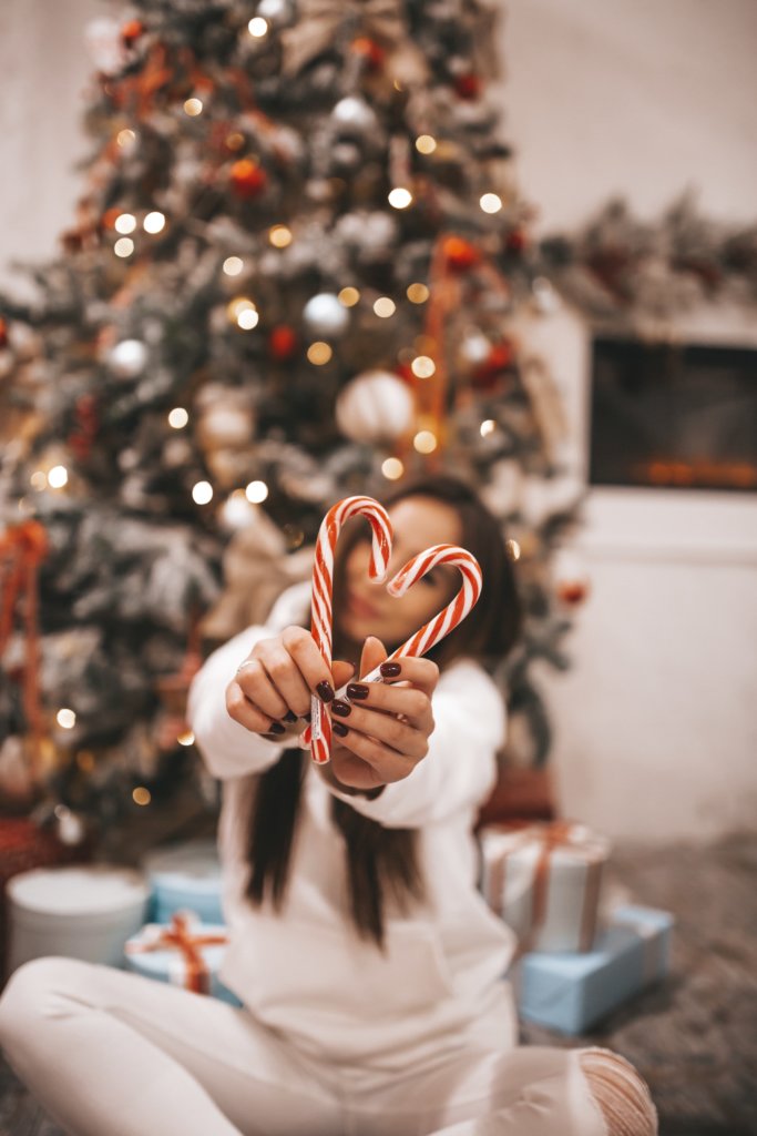 Women showing a heart with candy canes
